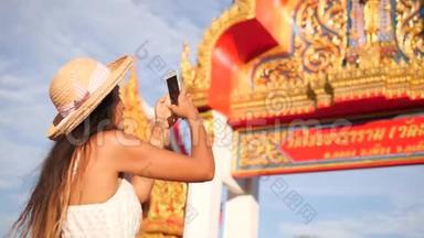 年轻的混血<strong>旅游</strong>女孩用手机拍照泰国佛寺。 泰国<strong>普吉岛</strong>。 4K，慢动作。